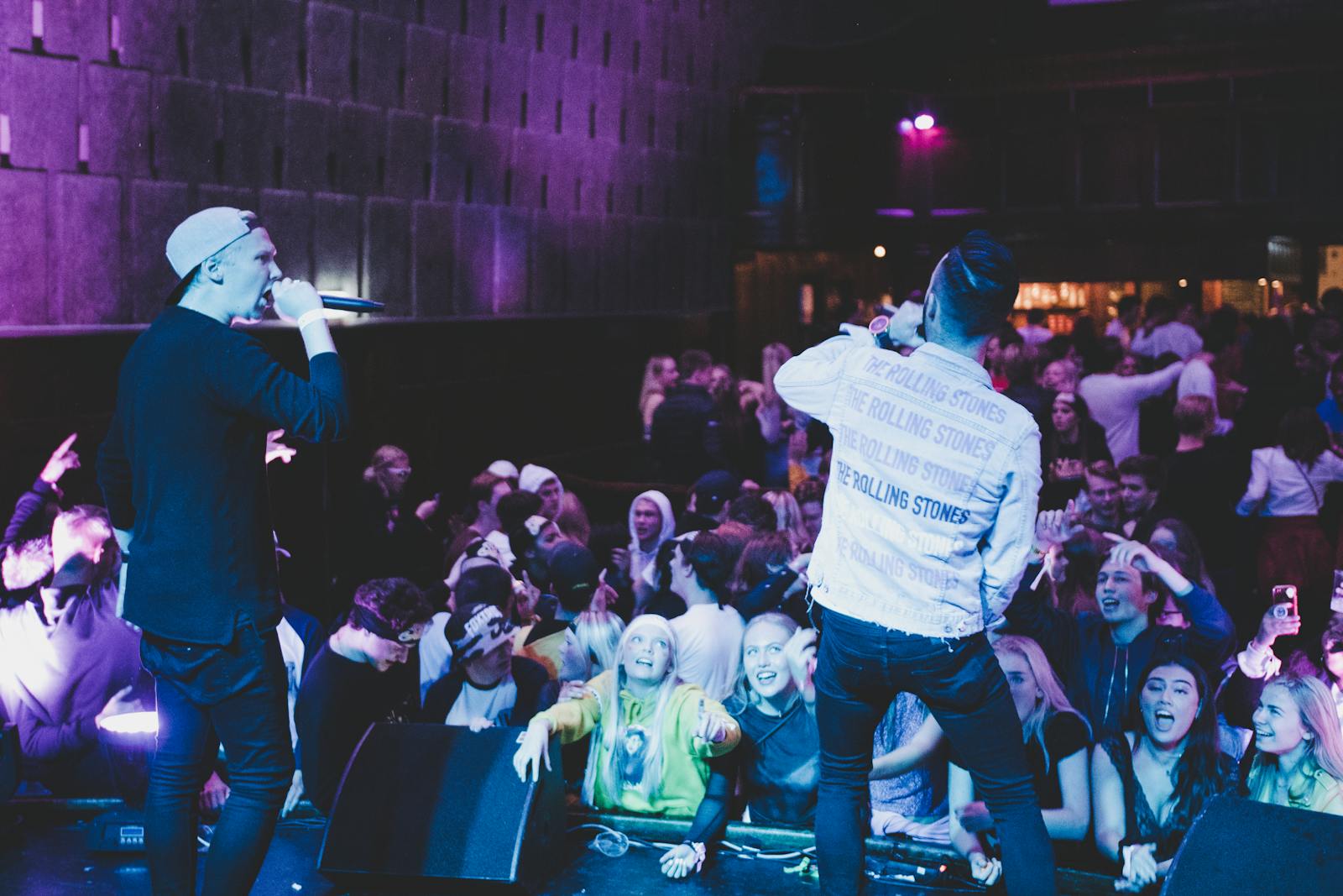 Dynamic photo of musicians performing at a lively concert with an enthusiastic crowd.
